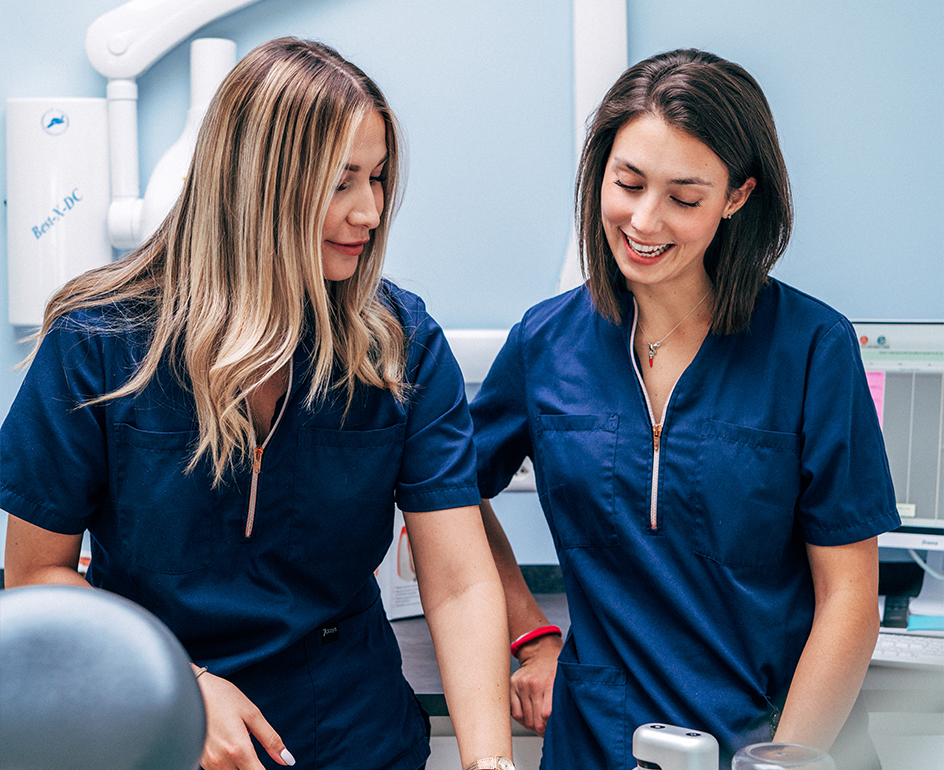 Two hygienists from our nyon dental practice smile at each other